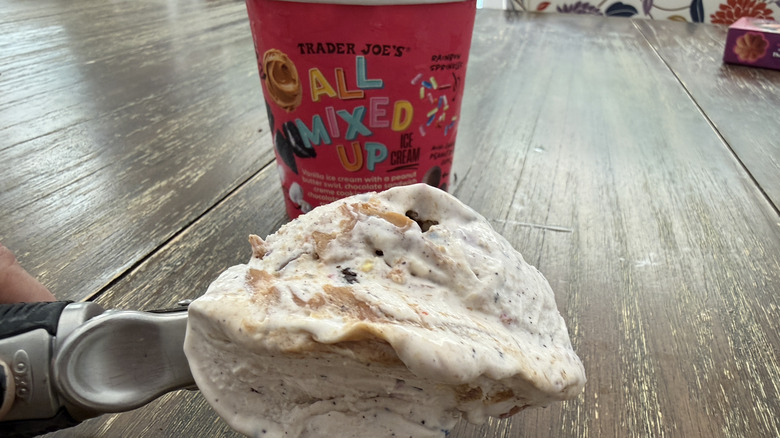 Trader Joe's All Mixed Up Ice Cream container on wooden table with a scooper full in the foreground