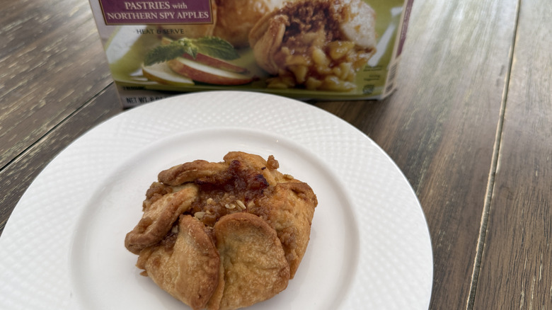 Trader Joe's Apple blossoms package and a piece on a white plate on a wooden table