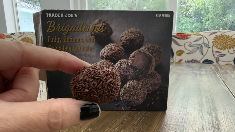 Trader Joe's Brigadeiros package on wooden table and a hand holding one