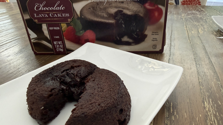 Trader Joe's Chocolate Lava Cakes package and a square, white plate with a cake split in half on a wooden table