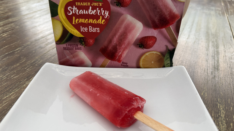 Trader Joe's Strawberry Lemonade Ice Bars package and one unwrapped on a square, white plate on wooden table