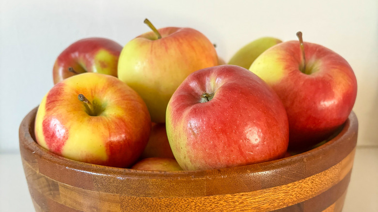 Yellow and red Ambrosia apples in a wooden bowl