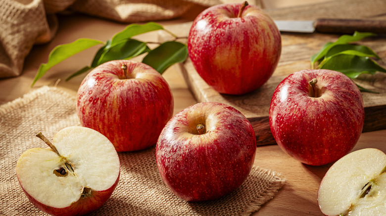 Gala apples on a wooden table with burlap place mats