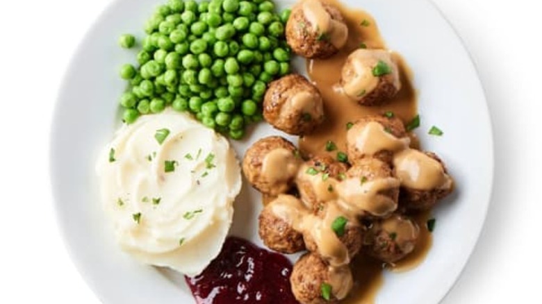 Ikea restaurant meatballs, gravy, mashed potatoes, and peas on a white plate