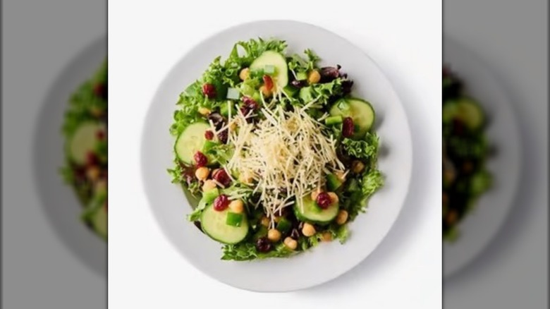 Ikea restaurant salad with chickpeas, cucumbers, craisins, and parmesan cheese on a white plate