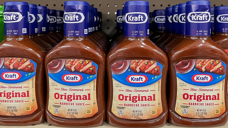 A shelf of Kraft Barbecue Sauce in bottles at the grocery store.