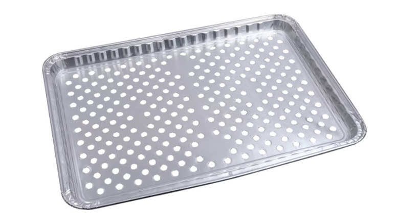 A foil tray with evenly spaced, round holes in it