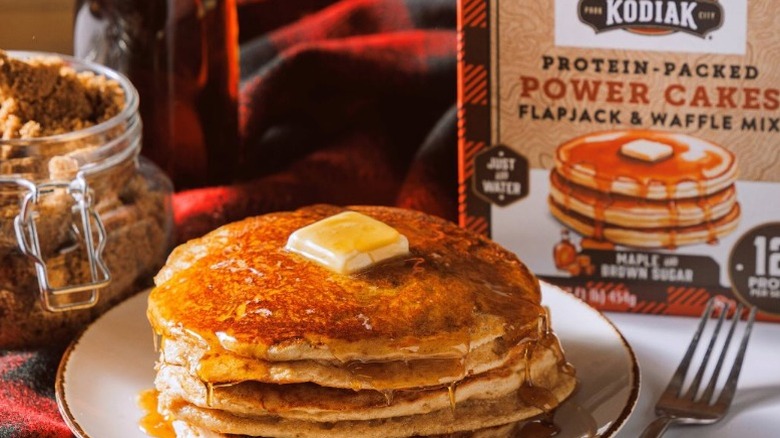 pile of pancakes on a plate next to a box of Kodiak mix