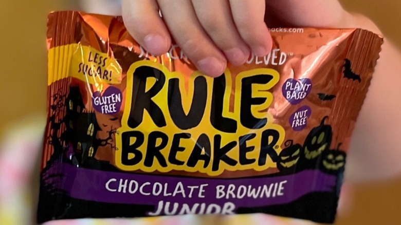 hand holding Rule Breaker brownie in Halloween packaging