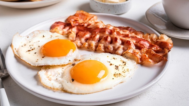 Plate with two fried eggs and bacon strips