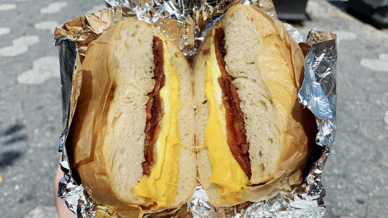 closeup of bacon egg and cheese held in foil wrapping