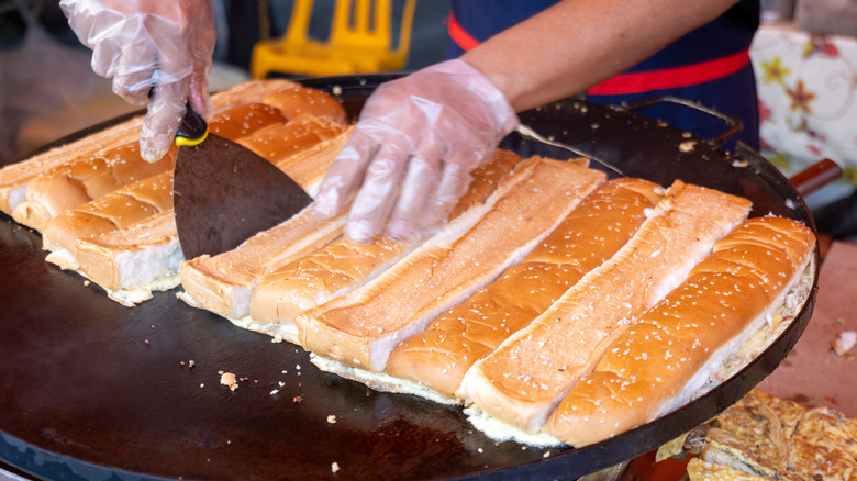 roti john sandwiches being made on griddle