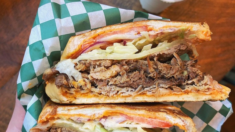closeup of tripleta sandwich with green checkered paper