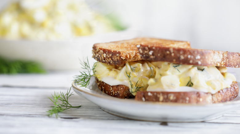 Egg salad sandwich on toasted whole grain bread with fresh dill