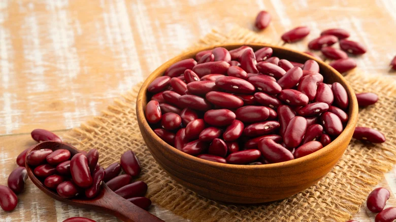 Raw kidney beans in wooden bowl by spoon
