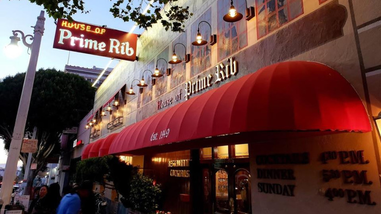 House of Prime Rib entrance at dusk with neon sign and red awning