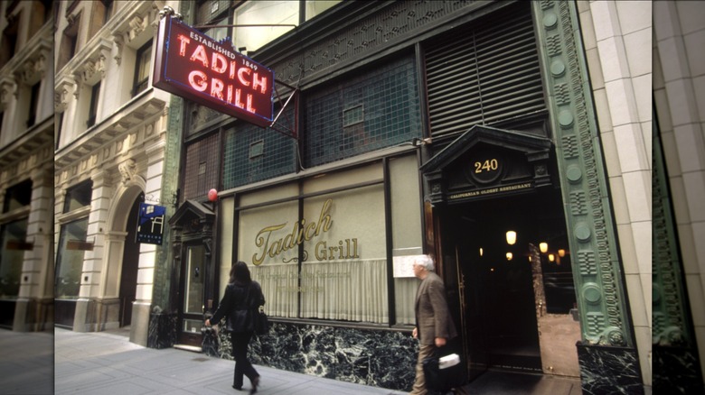Tadich Grill entrance with neon sign and passerby