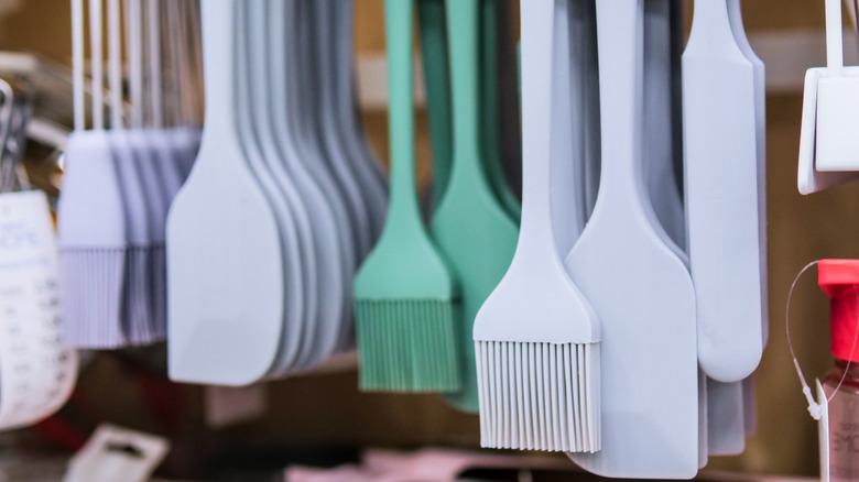 A hanging display of silicone basting brushes and spatulas in store