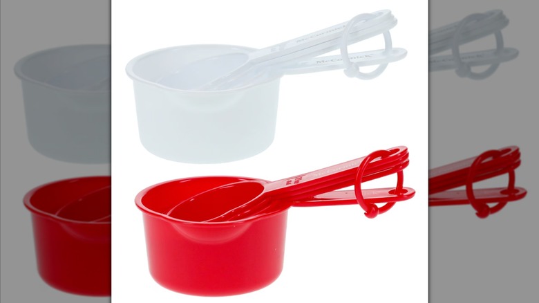 Two sets of Dollar Tree McCormick measuring cups, one in white and one in red