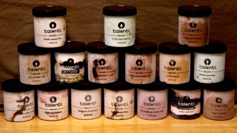 A selection of 16 flavors of Talenti brand gelato arranged on a table in front of a brown background