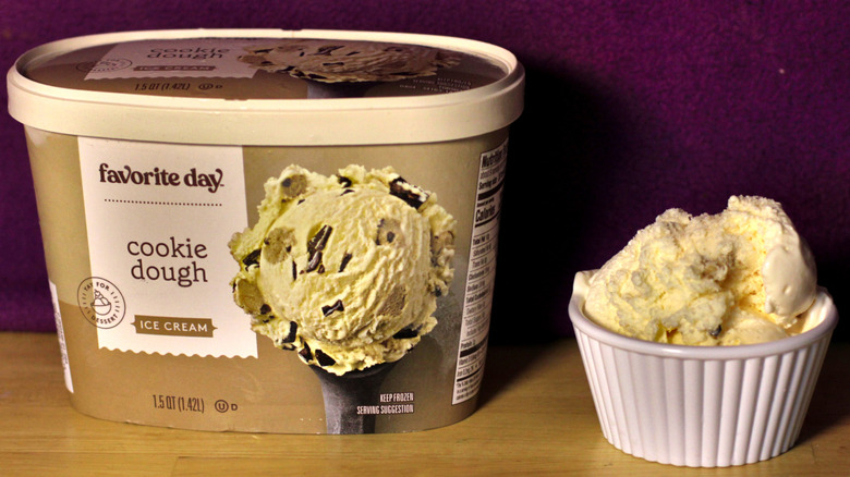A container of Target's Favorite Day brand cookie dough flavored ice cream beside a bowl of the scooped ice cream