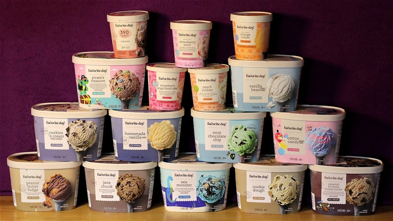 16 varieties of Favorite Day brand ice cream stacked on top of each other in a pyramid-like display against a purple background
