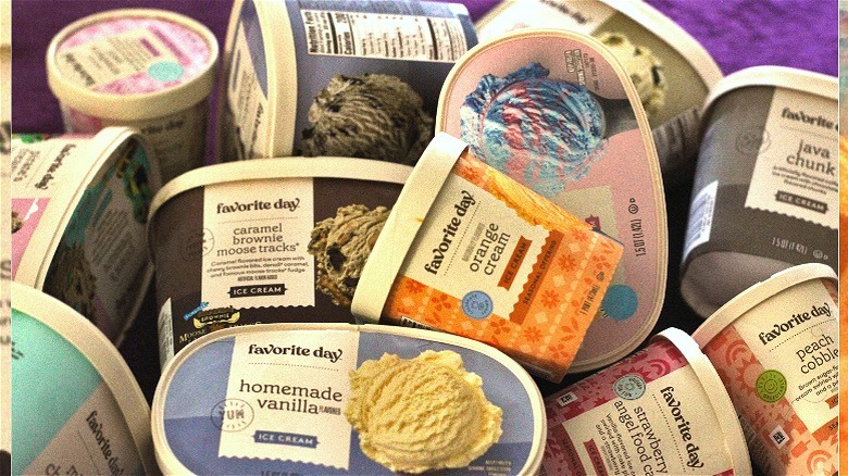 A jumbled pile of Favorite Day brand ice cream flavors on top of each other against a purple background