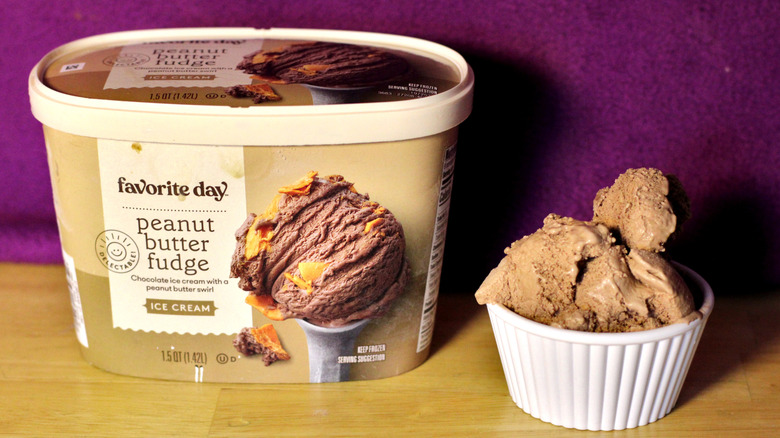 A container of Target's Favorite Day brand peanut butter fudge flavored ice cream beside a bowl of the scooped ice cream