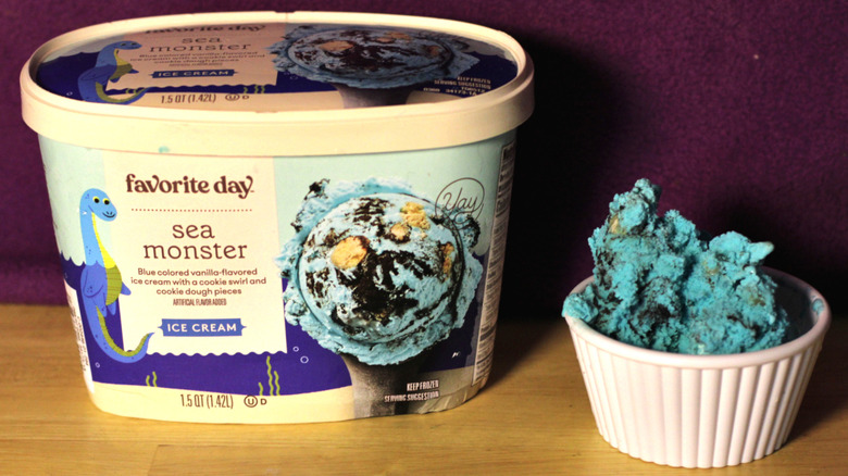 A container of Target's Favorite Day brand sea monster flavored ice cream beside a bowl of the scooped ice cream