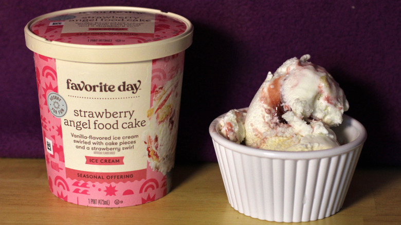 A container of Target's Favorite Day brand strawberry angel food cake flavored ice cream beside a bowl of the scooped ice cream