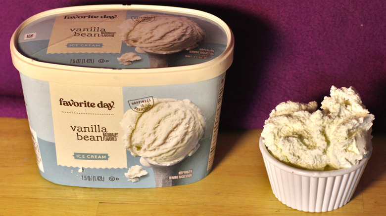 A container of Target's Favorite Day brand vanilla bean flavored ice cream beside a bowl of the scooped ice cream