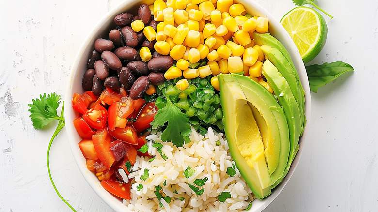 Bowl with rice, tomatoes, beans, corn, and avocado