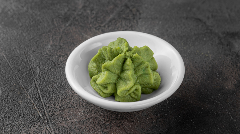 A small bowl of wasabi on a dark background