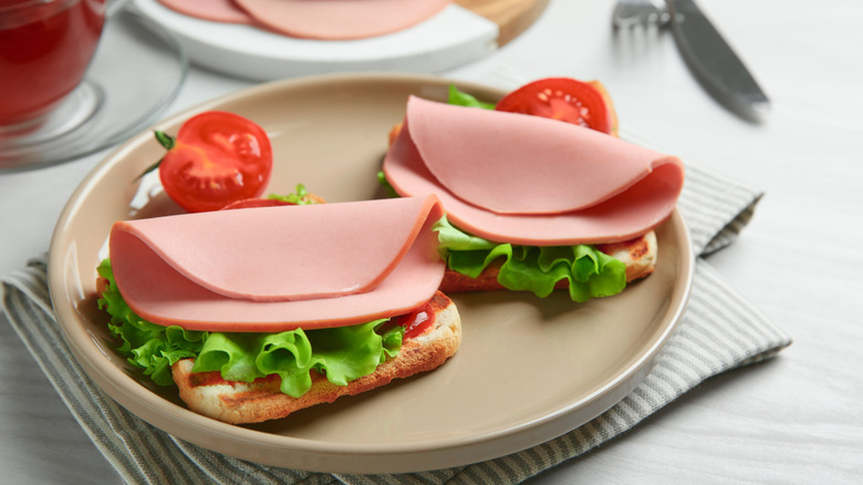 Bologna on bread with lettuce, tomato, and ketchup