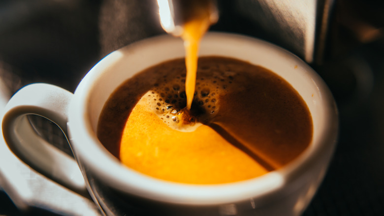 closeup of espresso drip into white mug