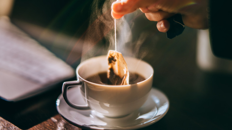 tea bag being steeped in white mug