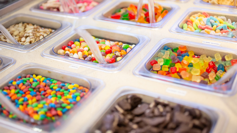 colorful toppings bar with plastic spoons