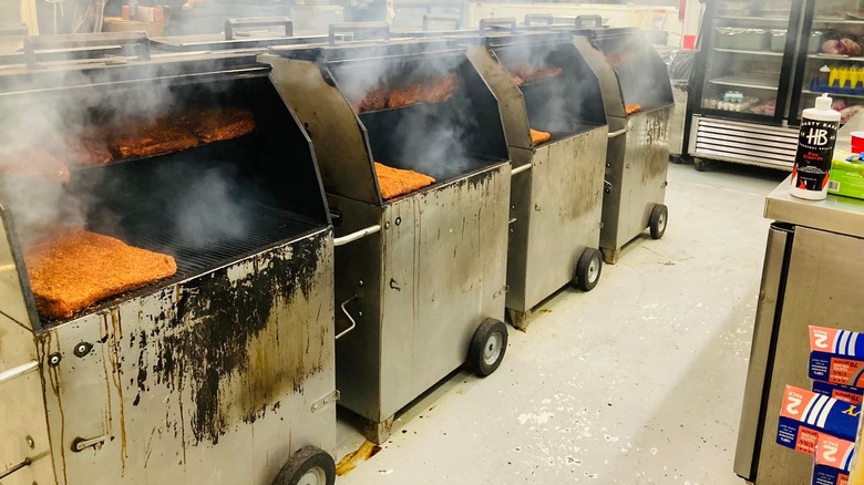Row of four smokers filled with meat