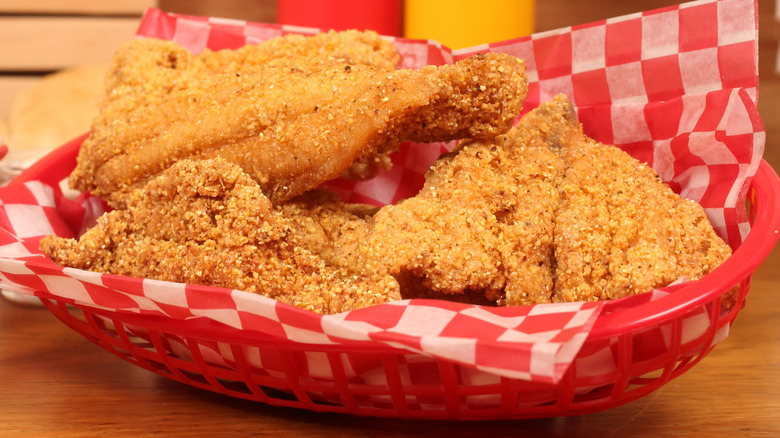 Crispy fried catfish on red and white checkered paper