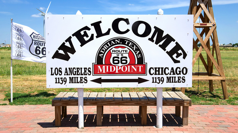White sign with black letters showing 1,139 miles to both Los Angeles and Chicago