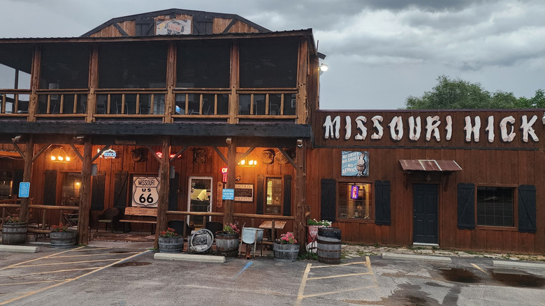 Rustic, log cabin exterior with old-fashioned sign that says Missouri Hick
