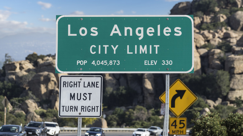 Green and white Los Angeles city limit sign on side of road