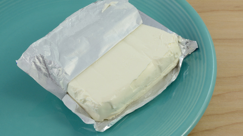 A block of cream cheese in a foil wrapper