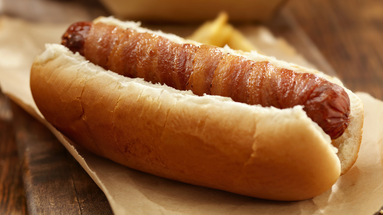 A bacon-wrapped sausage in a bun