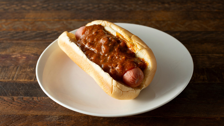 A chili dog on a white plate