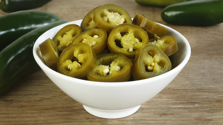 A bowl of pickled jalapeños on a counter