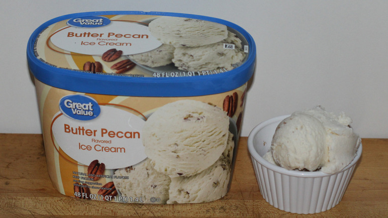 Great Value butter pecan ice cream container with a bowl of scooped ice cream beside it