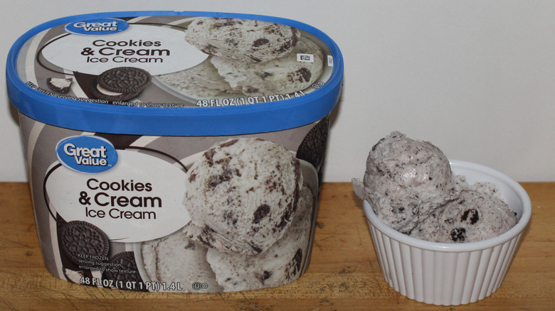 Great Value cookies & cream ice cream container with a bowl of scooped ice cream beside it