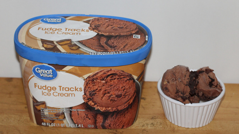 Great Value fudge tracks ice cream container with a bowl of scooped ice cream beside it