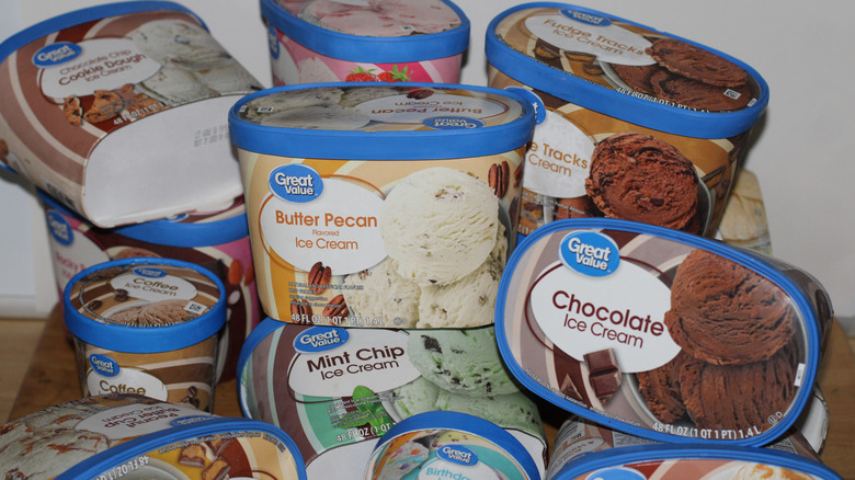 A pile of different Great Value ice cream containers, including flavors like chocolate, butter pecan, and cookie dough